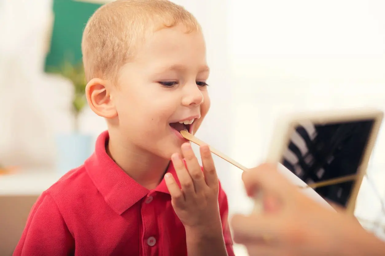 Little boy during lesson with his speech therapist.